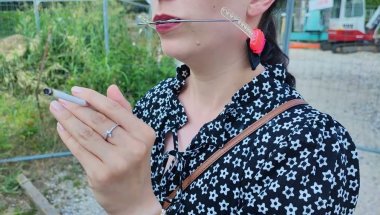 Lady smoking cigarettes wearing braces and headgear